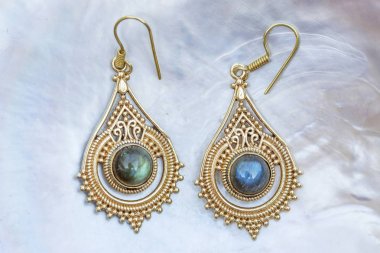 İnci arka planda mineral labradorit değerli taşlı pirinç metal küpeler
