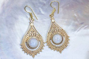 İnci arka planda mineral ay taş taş taş ile Pirinç metal küpe