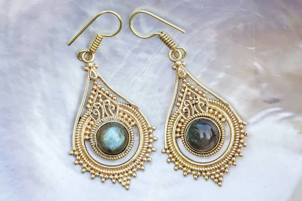 İnci arka planda mineral labradorit değerli taşlı pirinç metal küpeler