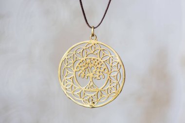 Nötr arka plan üzerinde Pirinç metal ağaç şeklinde kolye yuvarlak mandala