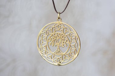 Nötr arka plan üzerinde Pirinç metal ağaç şeklinde kolye yuvarlak mandala