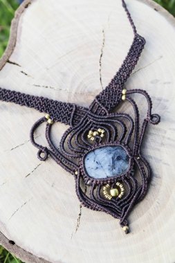 Ahşap arka planda doğal mineral değerli taş ile macrame kolye