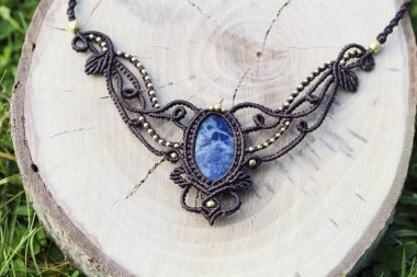 Ahşap arka planda doğal mineral değerli taş ile macrame kolye