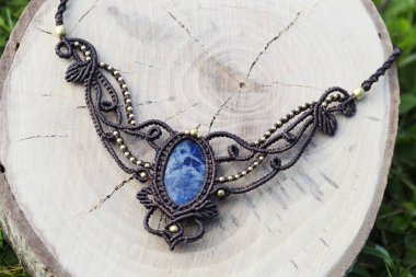 Ahşap arka planda doğal mineral değerli taş ile macrame kolye