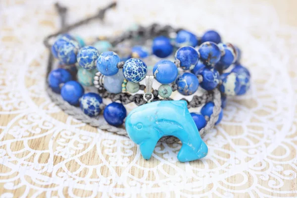 Dolphin mineral stone turquoise pendant bead necklace on decorative background