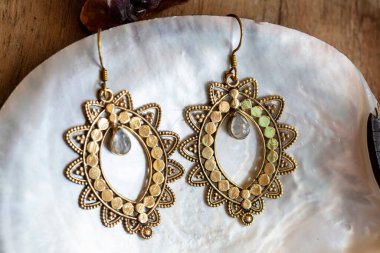 Kabuk zemininde güzel doğulu pirinç küpeler.