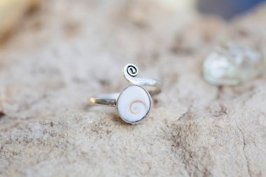 Kabuk beyazı süslemeli beyaz metalden bir yüzük.