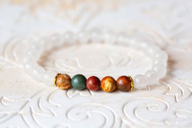 Beyaz dekoratif arka planda mineral taş bilezik