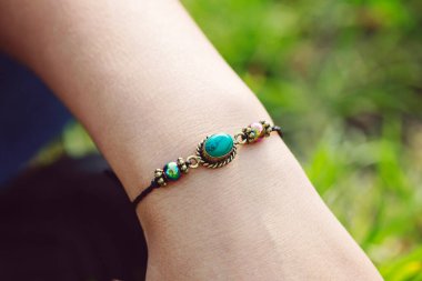 Kadın bileğinde mineral taşından bilezik kolye. 