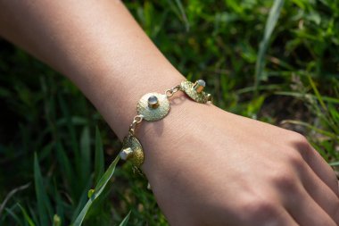 Pirinç mücevher bilezik takan bir kadın.