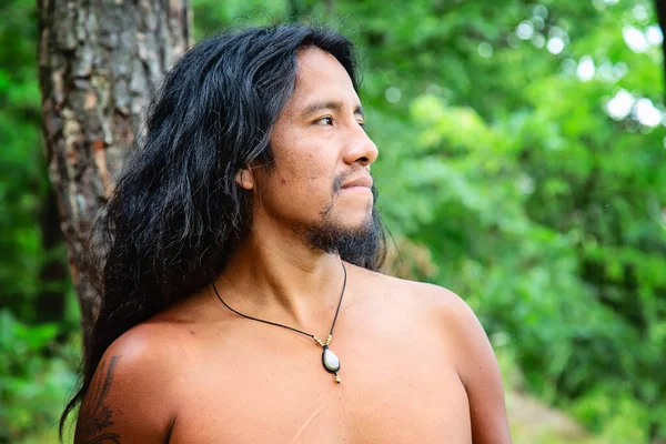 Young native american man in the forest with crystal quartz necklace