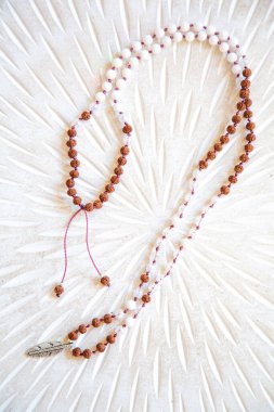 Beyaz arka planda Hint tohumu ve beyaz yeşil boncuk mala kolye