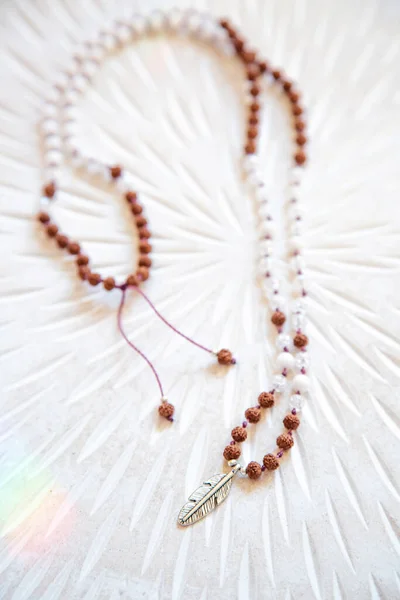 Indian seed and white jade beads mala necklace on white background