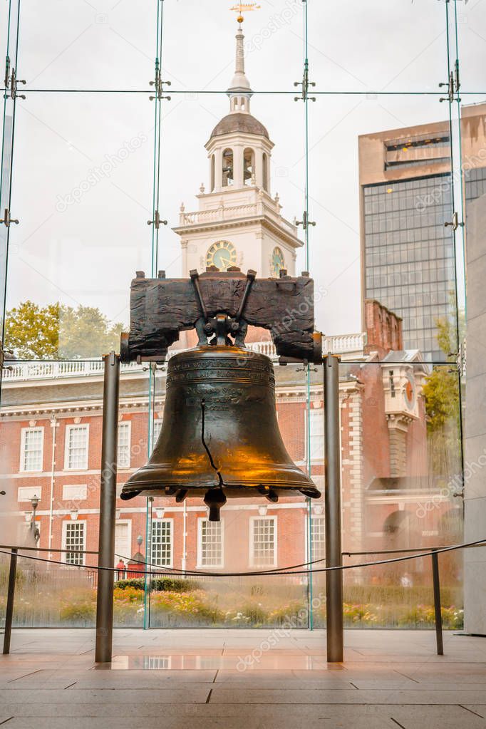 Portrait shot of the liberty bell with Independence Hall in the background