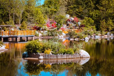 Island in the middle of the pond at the japanese gardens in Grand Rapids Michigan on a sunny spring day clipart