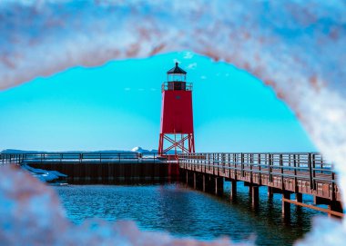 Kış mevsiminde Michigan Gölü 'ndeki buz tabakasının içinden kırmızı ışıklı bir evin görüntüsü.