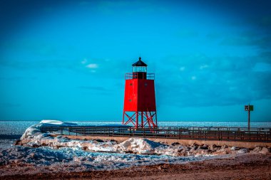 Charlevoix Michigan 'da donmuş bir plajın üzerinde duran parlak kırmızı deniz feneri