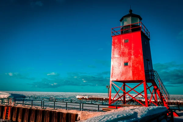 Kışın Charlevoix Michigan 'daki deniz fenerinden altın saat yansımaları