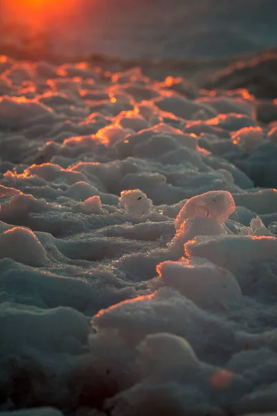 ミシガン州ペトスキーの日没時にビーチに沿って凍結した氷の閉鎖 — ストック写真