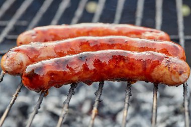 Izgarada ateşli sosisler olan Bbq 'a yaklaş