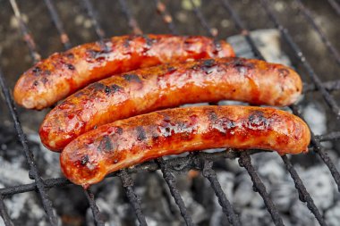 Izgarada ateşli sosisler olan Bbq 'a yaklaş