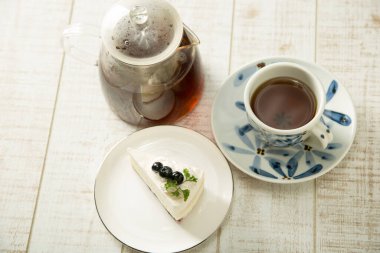 Böğürtlenli kek ve çay masada.