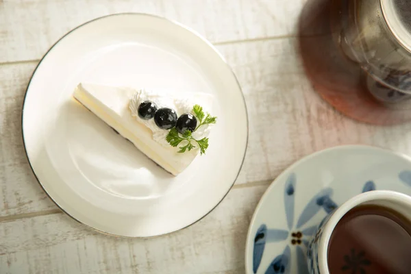 Böğürtlenli kek ve çay masada.