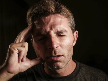 genç çekici ve üzgün adam depresyon ve stres bakarak tempo kafasına el ile baş ağrısı acı endişeli ve sağlık ve migren kavramı siyah arka plan üzerine hasta izole