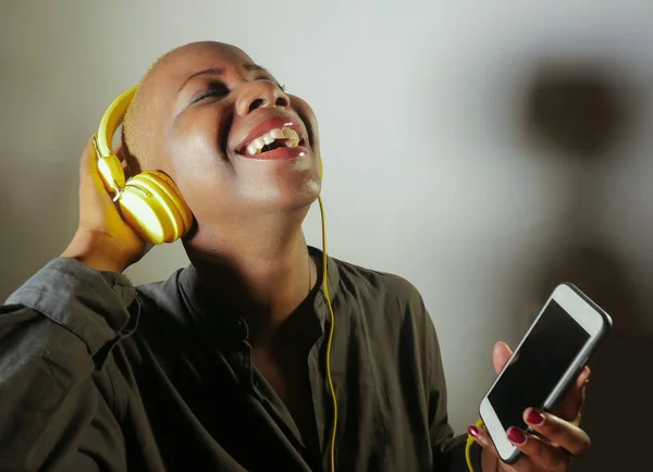 Junge Glückliche Und Attraktive Afroamerikanerin Mit Gelben Kopfhörern Und Mobiltelefon — Stockfoto