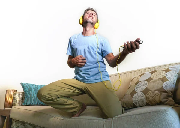 Jovem Feliz Animado Homem Pulando Sofá Sofá Ouvindo Música Com — Fotografia de Stock