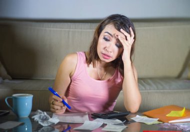 genç çekici vurguladı ve hesap makinesi ve aylık giderleri ve borç yorgun hesaplama ve yerli mali sorun ve vergi kavramı içinde boğulmuş makbuzları ile İspanyol kadın endişeli