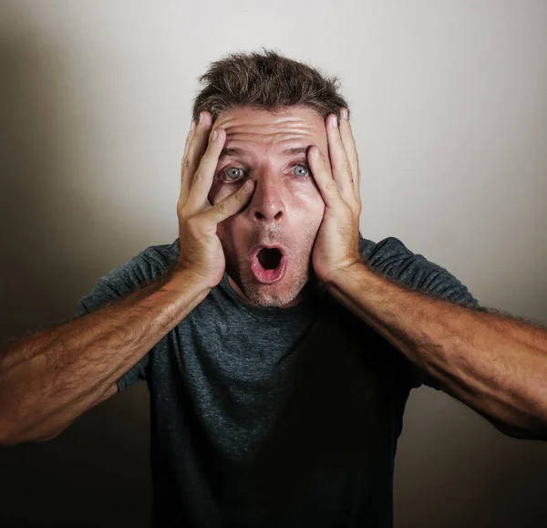 portrait of young attractive and surprised man gesturing in shock and disbelief overacting in shocked hands gesture on isolated background in surprise emotion and face expression concept