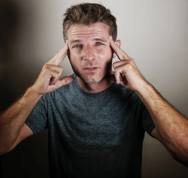 portrait of young attractive sad and depressed man looking tired and exhausted suffering stress and depression on isolated background in worried face expression and upset emotion concept