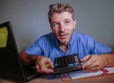 Genç deli vurguladı ve umutsuz ofis masası dizüstü bilgisayar duygu iş ve iş sorun yaşam tarzı kavram açısından hesap makinesini kullanarak boşa çıkarmak ile dağınık çalışan adam boğulmuş