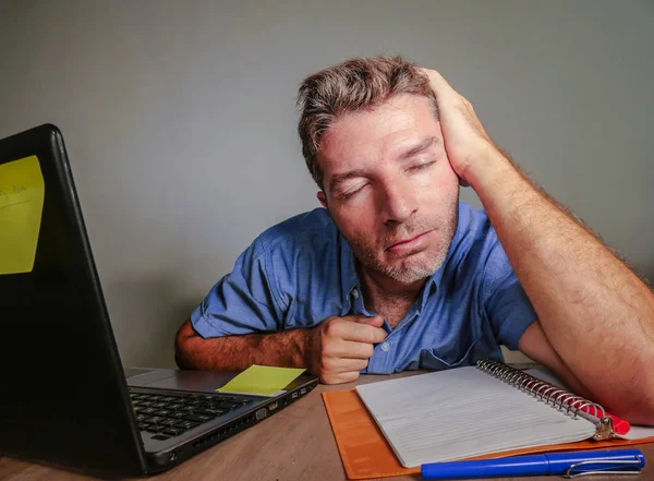 young crazy stressed and overwhelmed man working messy at office desk desperate with laptop computer feeling exhausted and frustrated in business and work problem lifestyle concept