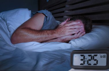 üzgün genç çekici adam uyanık gözlerini depresif bozukluğu uyku uykusuzluk acı ağlayan ve umutsuz çalar saat ile geç gece saat işaret kapsayan yatak uykusuz yatan endişeli