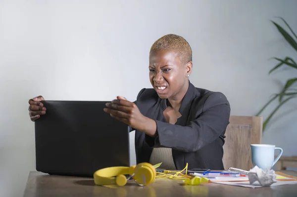 stressed and frustrated afro American black woman working overwhelmed and upset at office laptop computer desk gesturing angry in stress looking tired in business and work problem concept