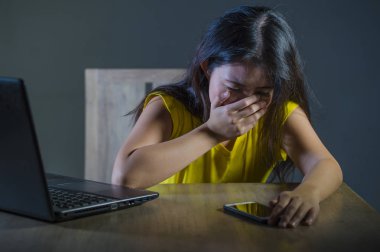 dramatik portre korkmuş ve Asyalı Koreli Genç kız ya da dizüstü bilgisayar ve cep telefonu takip ve taciz kesmek parola ile siber zorbalık acı genç kadınla vurguladı