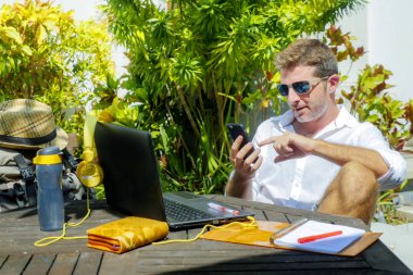 Açık havada kahve dükkanı dizüstü bilgisayar rahat ve güvenli seyahat ve iş seyahat yaşam tarzı kavramı ile çalışan genç çekici ve mutlu dijital göçebe erkeğin