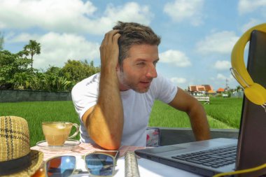 dizüstü bilgisayar ve cep telefonu ile açık havada satırındaki çevirmen ve bağımsız iş Internet serbest çalışma ve girişimci olarak çalışan genç çekici dijital göçebe adam