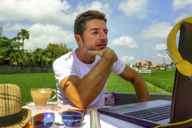 dizüstü bilgisayar ve cep telefonu ile açık havada satırındaki çevirmen ve bağımsız iş Internet serbest çalışma ve girişimci olarak çalışan genç çekici dijital göçebe adam