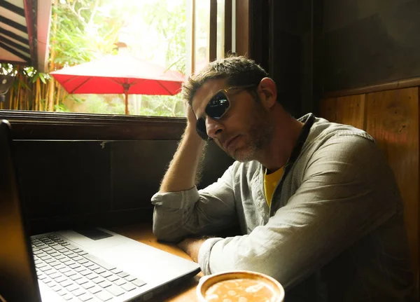 魅力的な思慮深く 物思いにふける千年男性インターネット喫茶店ラップトップ コンピューターを考えて起業家現代のデジタル遊牧民の成功したフリーランスの仕事の概念でリラックスしてから作業 — ストック写真