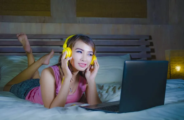 Молодая Красивая Счастливая Девушка Слушает Музыку Желтых Наушниках Ноутбуке Улыбается — стоковое фото