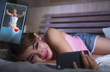 line dating ve hücresel teknoloji içinde gülümseyen ve çocuklar profilleri gönderme izlerken cep telefonuyla internet sosyal medya uygulaması üzerinde flört yatakta yatan genç güzel ve mutlu kız seviyor 