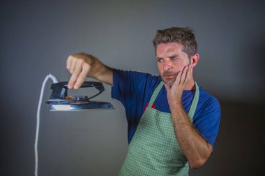 Sanki bir tuhaf ve garip aygıtı dağınık kocası veya tek merak guy yerli işi ve oda temizliği Ütü tutan genç çekici ve düşünceli adam komik portresi