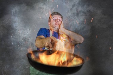 önlük mutfak felaket ve yerli yemek vasıfsız ve unexperienced korkunç ev aşçı gıda yanan ateşi tavada tutan adamla genç çekici ve şok dağınık ev aşçı