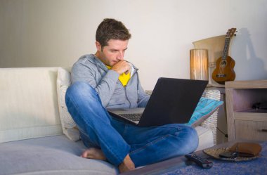 freelancer iş ve bağımsız iş yaşam tarzı kavramı mutlu dizüstü bilgisayarda ağ kanepede oturan ev oturma odasından çalışan genç çekici ve başarılı erkeğin