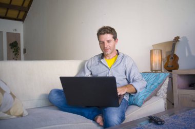 freelancer iş ve bağımsız iş yaşam tarzı kavramı mutlu dizüstü bilgisayarda ağ kanepede oturan ev oturma odasından çalışan genç çekici ve başarılı erkeğin