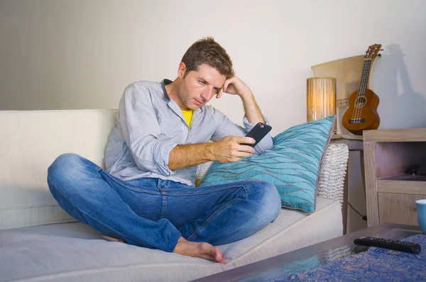 oturma odası kanepe oturan genç güzel çekici ve mutlu adam kanepede internet mobil dating veya hatta flört telefonu kullanarak ağ rahat zevk internet sosyal medya uygulaması