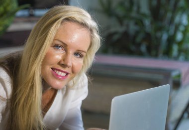 güzel ve sarışın bir kadın 40'lı modern yaşam tarzı concep dairede, kanepe kanepede rahat yalan laptop çalışma Internet kullanarak evde rahat mutlu portre kadar kapatın